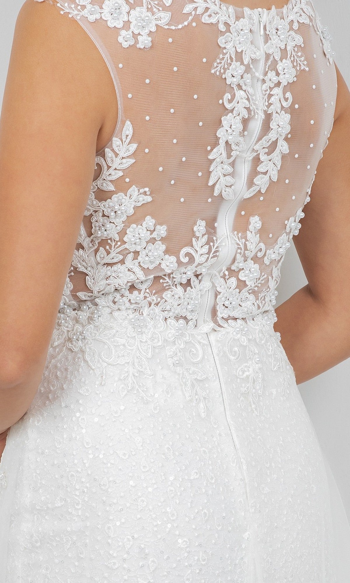 Close-up of the back of the Cinderella Couture 8506J long formal dress, showcasing its white sheer tulle fabric, intricate floral lace appliqués, and sophisticated button detailing.